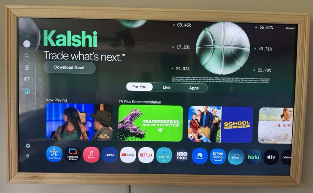 My Samsung TV's original home screen, with a large sponsored ad across the top and recommended shows filling the screen